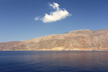Little cloud on a large mountain in a tranquil and beautiful sea