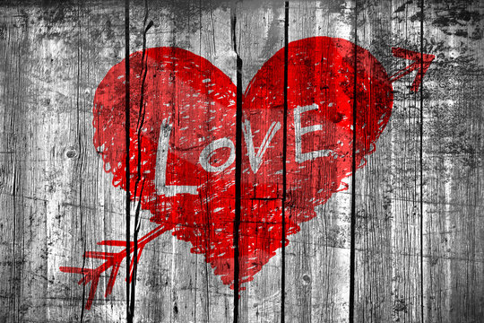 Drawing of a heart with word "Love" on grunge wooden wall