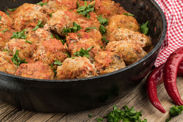 meat balls with herbs in pan on wooden rustic background