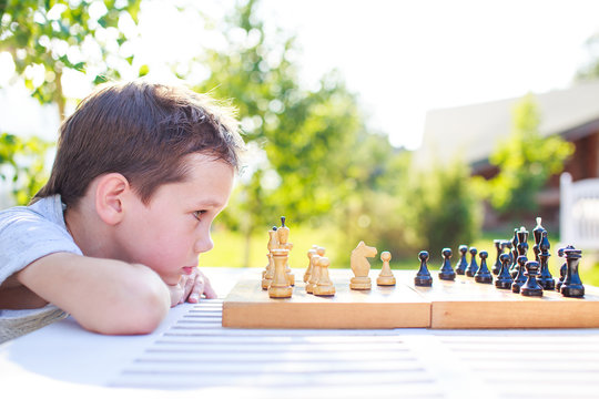 young chess player outdoors. the boy concentrating on the game of chess. view profile