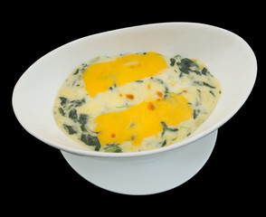 Baked spinach with cheese isolated on the black background with clipping path