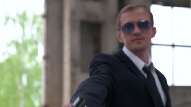 killer shoots a gun with a silencer