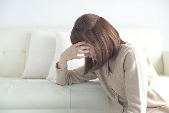 頭に手をあてる女性
