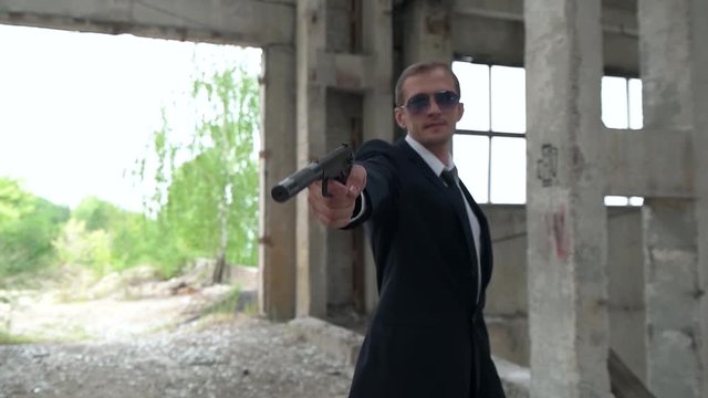 killer shoots a gun with a silencer