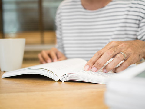  Closeup man hand open and reading a book
