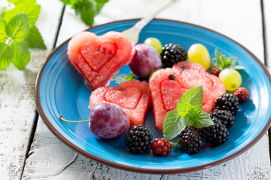 Slice of watermelon and berry fruit on wooden background, a popu