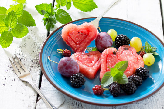 Slice of watermelon and berry fruit on wooden background, a popu