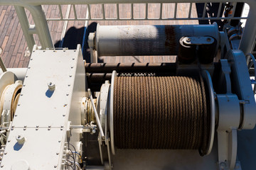 Large spool with steel wire on a tugging winch on a ship.