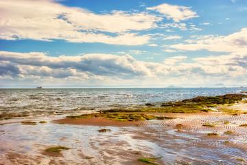 Fototapeta na wymiar Coastal landscape at low tide in Scotland, UK. The town of Kirkc