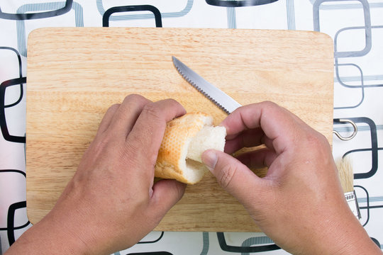 Hand with knife penetrate bread