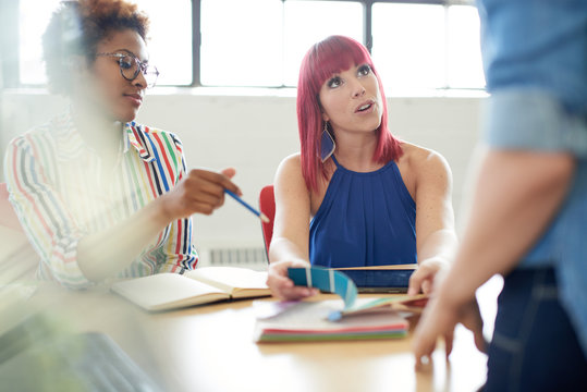 Unposed group of creative business people in an open concept office brainstorming their next project.
