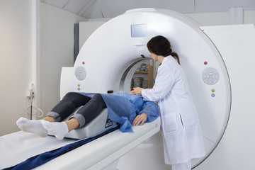 Female Doctor Preparing Patient For CT Scan
