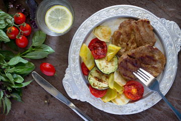Grilled steak meat pork and grilled vegetables on brown stone ba