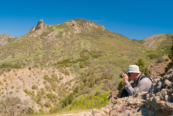 Photographer is taking photos on Kara-dag (extinct volcan) natural reserve, Eastern Crimea