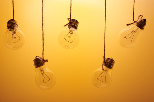 five incandescent light bulbs on a yellow background