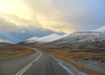 Fototapeta na wymiar On the Country Road through Snow Capped Mountain, Iceland 