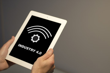 Hands holding white tablet with industry 4.0 concept on the screen. All graphics are made up.