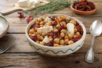 ceci insalata con pomodori secchi e formaggio sfondo tavolo di cucina rustico