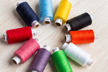 Bobbins threads multicolored. Old sewing tools on the wooden background.