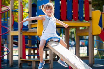 Fototapeta na wymiar Little beautiful girl playing in the playground