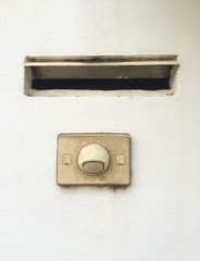 Old modern doorbell ring button with mailbox built-in on wall. Mobile photography