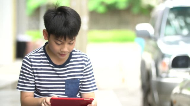Asian boy using smart cell phone near the road ,Bangkok Thailand