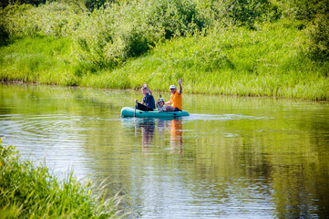 Fototapeta na wymiar Family with children ride inflatable rubber boat on the river .