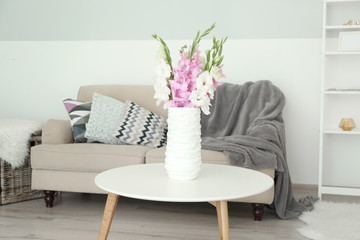 Room with bouquet of flowers in vase on wooden table