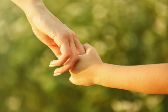 Parent and child holding hands outdoor