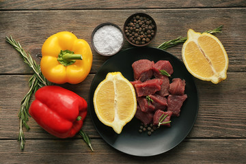 Raw meat with spices and vegetables on table