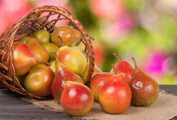 pears in a wicker basket on wooden table with blurred background