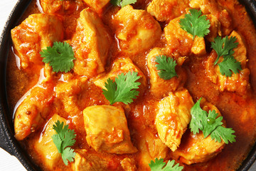 Tasty chicken curry in pan, close up