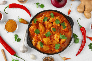 Chicken curry with vegetables on wooden background