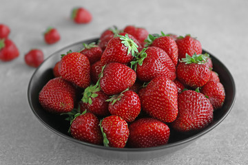 Fresh strawberries in plate on table