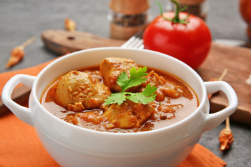 Tasty dinner chicken curry in soup plate on table
