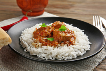 Tasty dinner with chicken curry and rice on plate