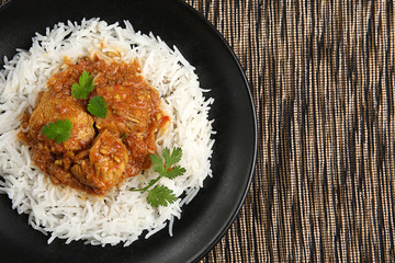Tasty dinner with chicken curry and rice on plate, closeup