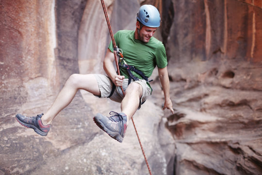 Man rappelling down from mountain