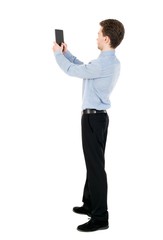 back view of standing business man photographing a phone or tablet. curly-haired businessman in light shirt photographed on a Tablet PC.