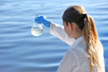 Woman with flask for expertise. Environmental pollution concept