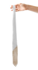 Female hand holding white tie, isolated on white