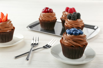 Delicious chocolate cupcakes on white table