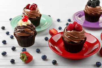 Delicious cupcakes on colorful plates