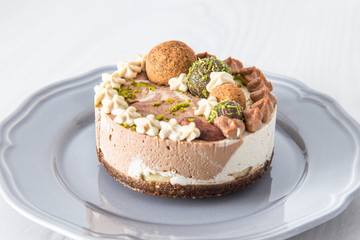 Raw vegan cake with lime, banana and chocolate, decorated with lime zest and chocolate balls. 