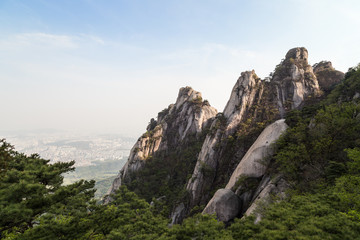 Fototapeta na wymiar View of steep granite peaks of Jaunbong Peak on Dobongsan Mountain at the Bukhansan National Park in Seoul, South Korea. Copy space.
