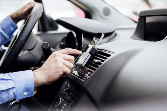 Cropped image of businessman using GPS on smart phone in car