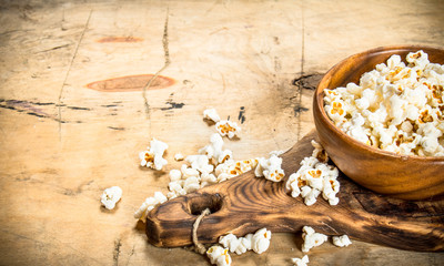 Obraz na płótnie Canvas Popcorn in a wooden bowl on the Board.