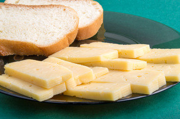 Plate glass with slices of dry cheese and white bread