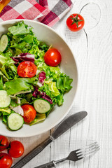 Salad of tomatoes and cucumbers with greens .
