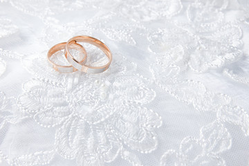 Obraz na płótnie Canvas Wedding rings on wedding card, on a white wedding dress